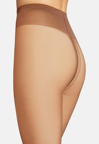 Collant trasparenti color nude con un cinturino solido marrone. Il materiale appare liscio ed elastico, progettato per una vestibilità aderente, con una finitura senza cuciture.