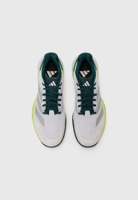 Baskets de sport avec tige en maille blanche, accents verts et lacets teal foncé. Présente trois bandes grises sur les côtés et une semelle en caoutchouc.