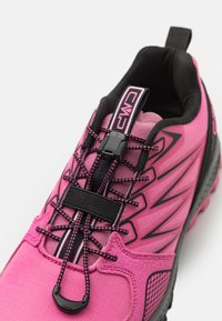 Rosa Sportschuh mit strukturiertem Obermaterial, elastischen Schnürsenkeln und verstärkter Zehenpartie. Verfügt über schwarze Akzente und eine Zuglasche an der Ferse.