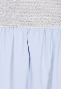 Világoskék szoknya texturált ezüst derékkal. Az anyag sima, alul gyűrött részletekkel a nagyobb térfogat érdekében.