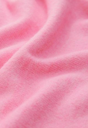 O țesătură moale, texturată, de culoare roz deschis, pliată în falduri, evidențiind un model de tricot fin și un aspect neted, confortabil.
