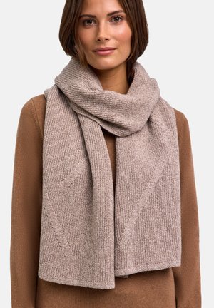 Écharpe en tricot de couleur marron clair avec une texture côtelée, drapée librement autour du cou. Le matériau semble doux et chaud, avec un léger éclat.