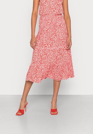 Roter Blumen-Midi-Rock mit einem gestuften Design, einem volantrichsten Saum und einem elastischen Bund. Kombiniert mit roten Open-Toe-High-Heels.