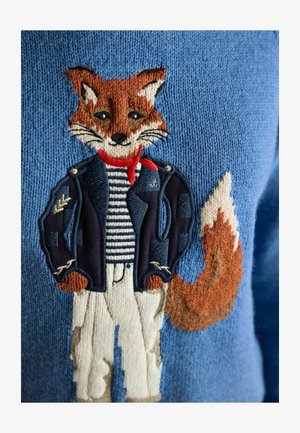 Fox character wearing a navy jacket, red scarf, striped shirt, and white pants embroidered on a blue knitted fabric.