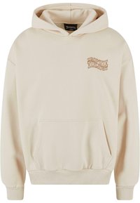 Beige hettegenser med kengurulomme og ribbestrikkede mansjetter. Har en liten brun grafisk logo på brystet, laget av mykt bomullsmateriale.