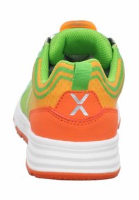 Zapatillas deportivas multicolores que presentan una tela verde y naranja, suela blanca y un destacado logo de "X" en el talón. Cuello de malla texturizada.