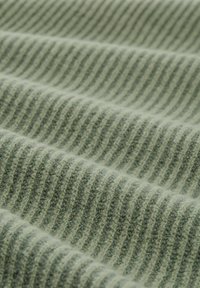 Gedämpfter grüner Strickstoff mit abwechselnden hellen und dunklen Streifen, der eine weiche Textur und sichtbare Nähdetails aufweist.