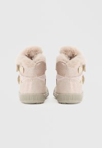 Botas rosa de media caña con parte superior brillante y collar de piel sintética. Estribos de velcro para el cierre. Suelas de goma texturizadas que proporcionan tracción.