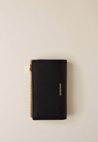 Portefeuille en cuir noir avec une fermeture éclair dorée et "BORBONESE" embossé en doré sur le devant, reposant sur une surface beige.