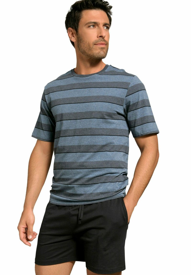 Pruhované tričko s krátkým rukávem v modré a šedé barvě, s kulatým výstřihem. Nosené s černými kraťasy, ruce v kapsách. Jednoduchý design, pohodlný styl.