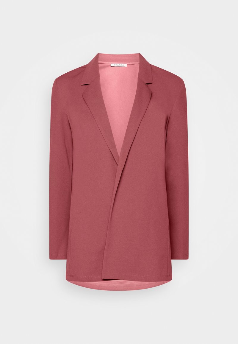 Blazer rose poudré à manches longues, avec revers crantés, devant ouvert et ourlet légèrement arrondi.