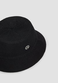 Black knit bucket hat with a structured crown, wide brim, and a small logo label on the side; features a textured weave pattern.