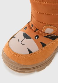 Oransje støvler med tigermotiv, stikkede detaljer, gummisåle og mykt overmateriale. Rund tå og luksus krage.