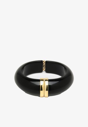 Black bangle bracelet made of glossy material, features two gold metallic accents at the center, and has a smooth, rounded design.