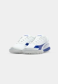 White sports shoes with blue accents, mesh and synthetic materials, textured toe cap, and patterned rubber sole. Laces and reinforced design visible.