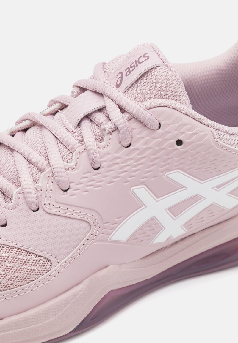 Helle rosa Sportschuh mit strukturiertem Obermaterial, Mesh-Einsätzen und weißem Logo. Verfügt über flache Schnürsenkel und eine durchsichtige Sohle.