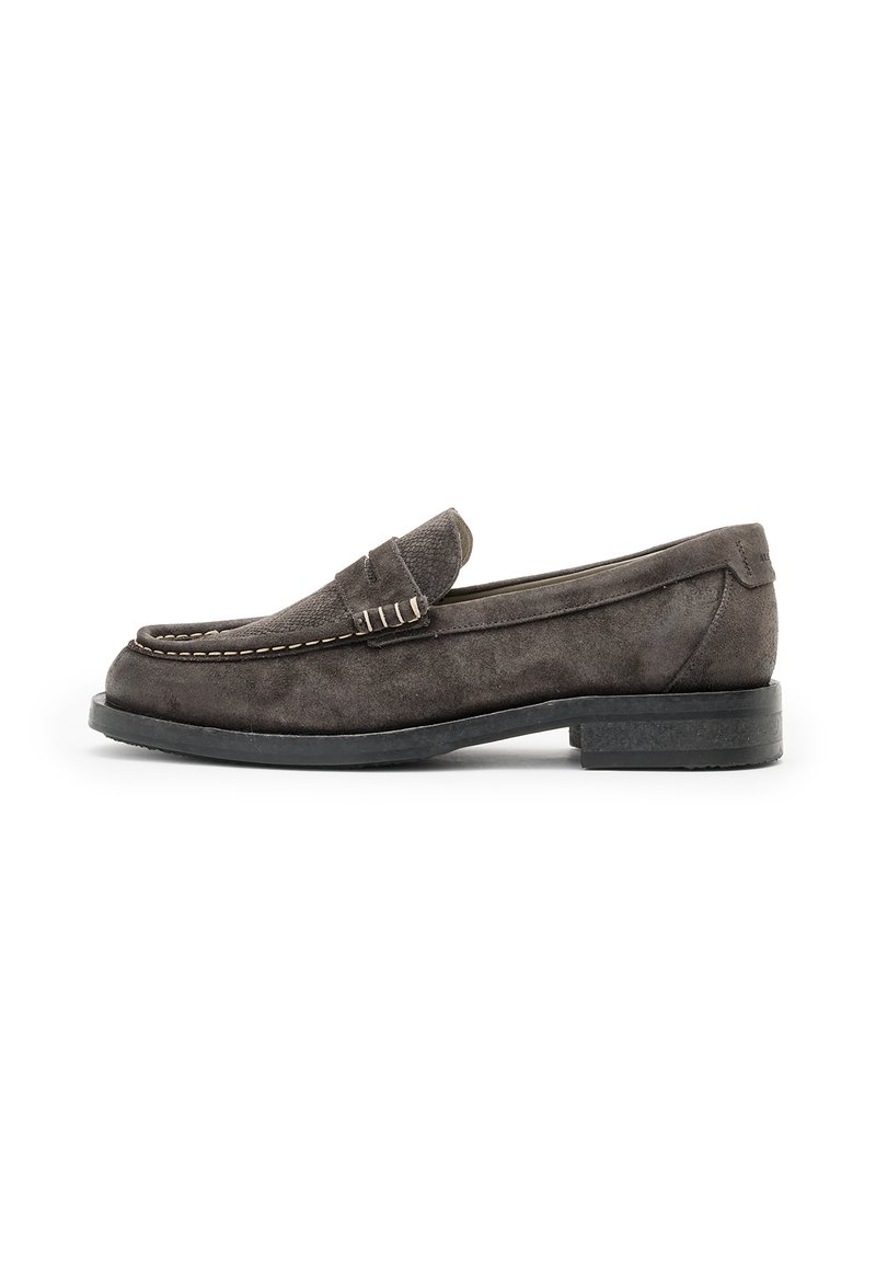 Grå mockaloafers med låg klack, detaljerad sömnad och ett texturerat läderrem över framsidan. Klassisk slip-on design.