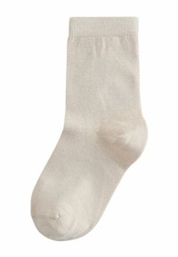 Vienas šviesiai smėlio spalvos medvilninis kojinėlis su gumuota apdaila, skirtas dėvėti iki vidurio blauzdos.
