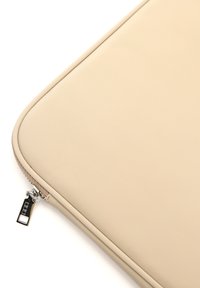 Bežna torbica za laptop od teksturiranog materijala s patentnim zatvaračem, opremljena srebrnim hardverom i glatkom površinom. Ukrašena suptilnim šavovima.