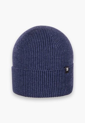 Marineblaue Strickmütze mit vertikal geripptem Muster, umgeschlagenem Bund und einem kleinen rechteckigen Markenetikett an der Seite.
