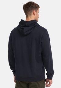 Mørkeblå hoodie med en blød tekstur, der har en snortrækshætte og ribbede manchetter. Bagsiden er ensfarvet uden synlige logoer eller mønstre.