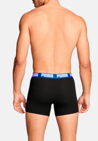 Schwarze Boxershorts mit einem blauen Puma-Logo am Bund, aus weichem Stoff, mit körpernaher Passform und mittlerer Oberschenkellänge.
