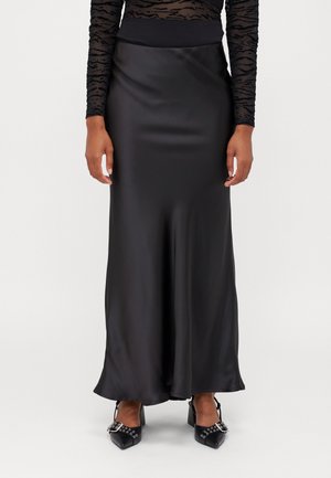 Fustă maxi din satin negru, cu un talie ajustată, textură netedă și o siluetă fluidă. Purtați cu pantofi cu toc înalt negri, cu accente de hardware.