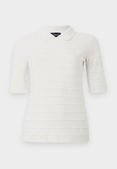 Valge lühikeste varrukatega polo särk, millel on tekstuuriga triibuline muster. Omab klassikalist krae ja sobivat lõiget. Valmistatud siledast materjalist.