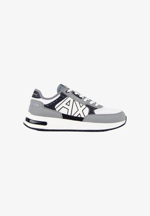 Witte, grijze en zwarte sneaker met "AX"-logo aan de zijkant, witte veters en een dempende zool met zichtbare zwarte luchtunit.