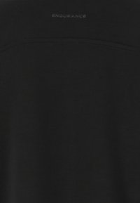 Svart sportskjorta i mjukt tyg, med en enkel design och ordet "ENDURANCE" subtilt tryckt nära halsringningen.