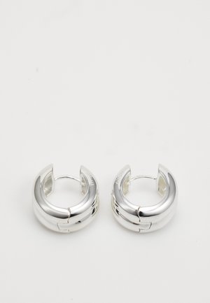 Orecchini a cerchio in argento con una finitura liscia e lucida. Design arrotondato, dotato di una chiusura a cerniera sicura, che riflette la luce in modo efficace.