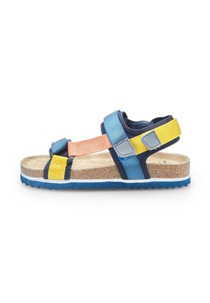 Sandaal met in elkaar geweven blauwe, oranje en gele banden, kurken voetbed en gemarmerde blauwe rubberen zool met zigzagpatroon.