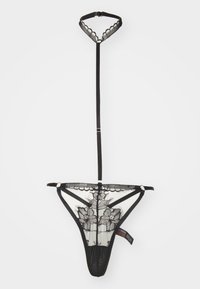 Ensemble de lingerie en dentelle noire avec un collier à bords festonnés et un string. Broderie florale sur tissu transparent avec des bretelles réglables et des détails en métal.