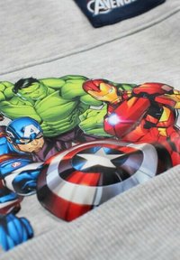 Sweat-shirt en tissu gris avec une impression colorée de super-héros : Hulk, Iron Man et Captain America, avec des poses dynamiques et des détails précis.