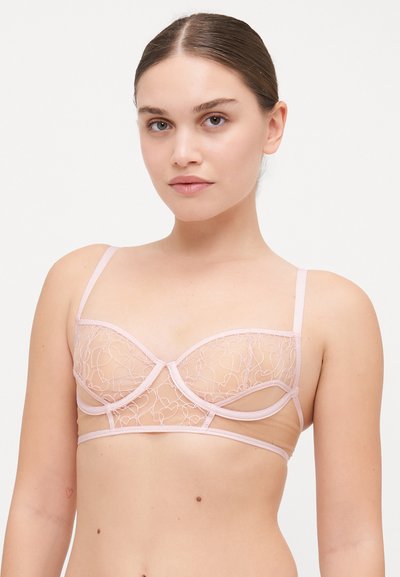 Sujetador rosa semitransparente con bordado de corazón, soporte de aros y tirantes ajustables. Textura suave con un diseño delicado.