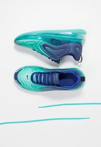 Paire de baskets Nike Air Max bleu sarcelle et bleu avec un design ondulé, une chaussure vue de côté, l'autre vue du dessus, lacets sarcelle en dessous sur fond blanc.