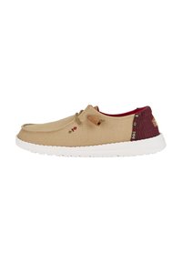 Scarpa slip-on in tela beige con dettagli burgundy, tomaia testurizzata, suola bianca e cuciture decorative. Presenta un dettaglio di lacci.