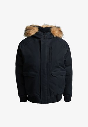 Crna parka jakna s kapuljačom obrubljenom krznom, zatvaranjem na rajsferšlus i dva bočna džepa. Ima rebraste manšete i glatku, teksturiranu vanjštinu.