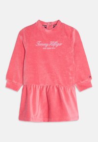 Różowa sukienka z długim rękawem dla małych dzieci wykonana z korduroju, z marszczonym dołem, prążkowanymi mankietami, zapięciem na zatrzask z tyłu na szyi oraz logo "Tommy Hilfiger New York City".
