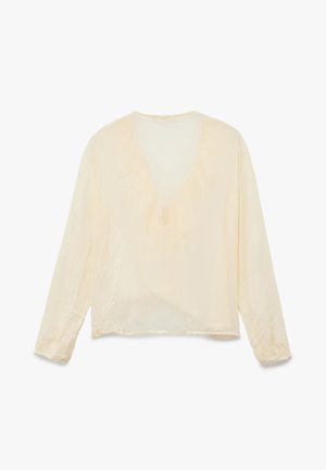 Blusa de manga larga color crema claro con escote en V, corte relajado, textura suave y detalles fruncidos en las muñecas. Tejido ligero y suave.