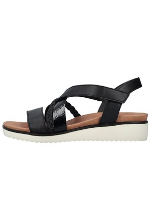 Sandale noire pour femme à bout ouvert avec des brides croisées, une semelle intérieure rembourrée couleur tan et une semelle compensée blanche.