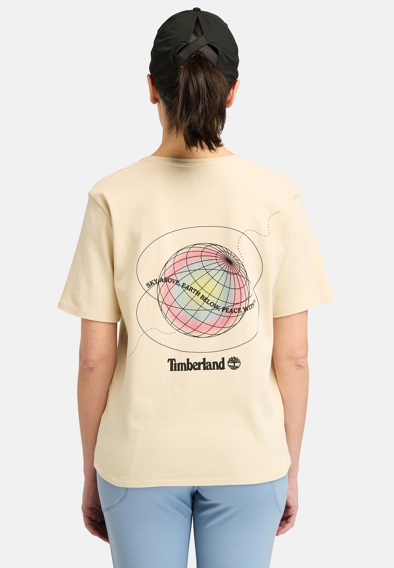 Lyhythihainen beige t-paita, jossa on monivärinen maapallon muotoilu ja teksti selässä, sekä musta logo alaosassa.