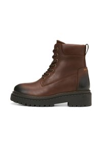 Bruine leren enkellaars met metalen oogjes, gevoerde kraag, trekhaak en dikke rubberen zool. Heeft een gladde en gestructureerde afwerking.