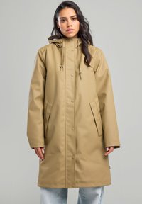Beige waterproof coat with a hood, snap buttons, two side pockets, and a relaxed fit, made from smooth, durable material.