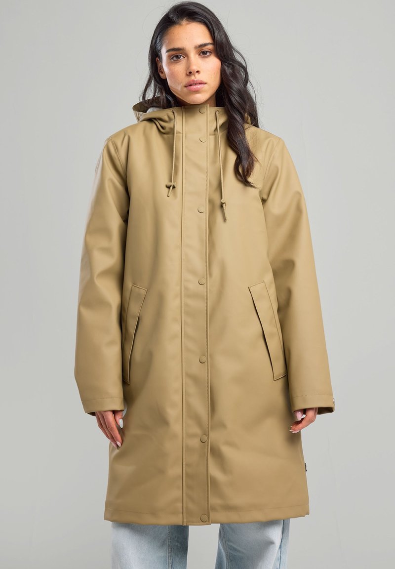 Beige waterproof coat with a hood, snap buttons, two side pockets, and a relaxed fit, made from smooth, durable material.