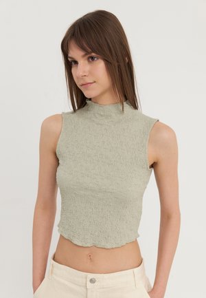 Green textured sleeveless crop top with a high neckline and scalloped hem, featuring a wrinkled fabric design.