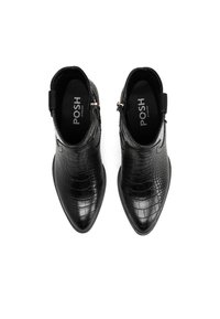 Botines negros con un acabado brillante de crococódilo, punta afilada y cremalleras laterales; el interior presenta el nombre de la marca "POSH."