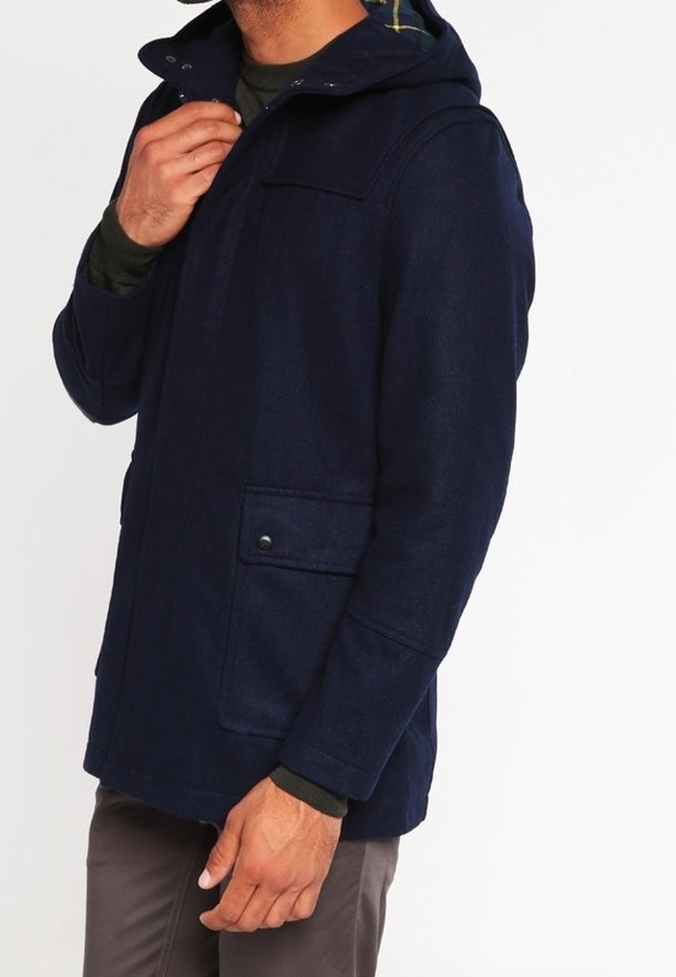 Mörkblå huva jacka i ullblandning, med två framfickor, tryckknappar och en rutigt foder synligt vid kragen.