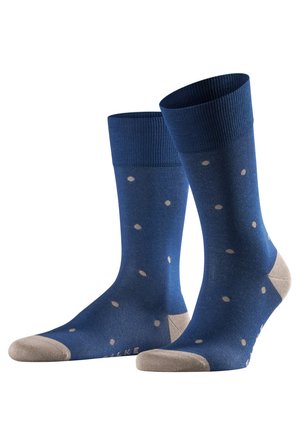 Blue socks with a ribbed cuff, featuring a polka dot pattern in beige and a beige toe and heel. Made from a smooth, stretchy material.