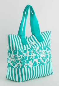 Torba typu tote z turkusowo-białym ozdobnym wzorem w paski i motywami kwiatowymi. Wykonana z trwałego materiału, ma kontrastujące uchwyty i pojemny design.